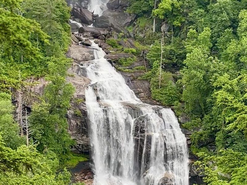 A waterfall stepping down a forested mountainside